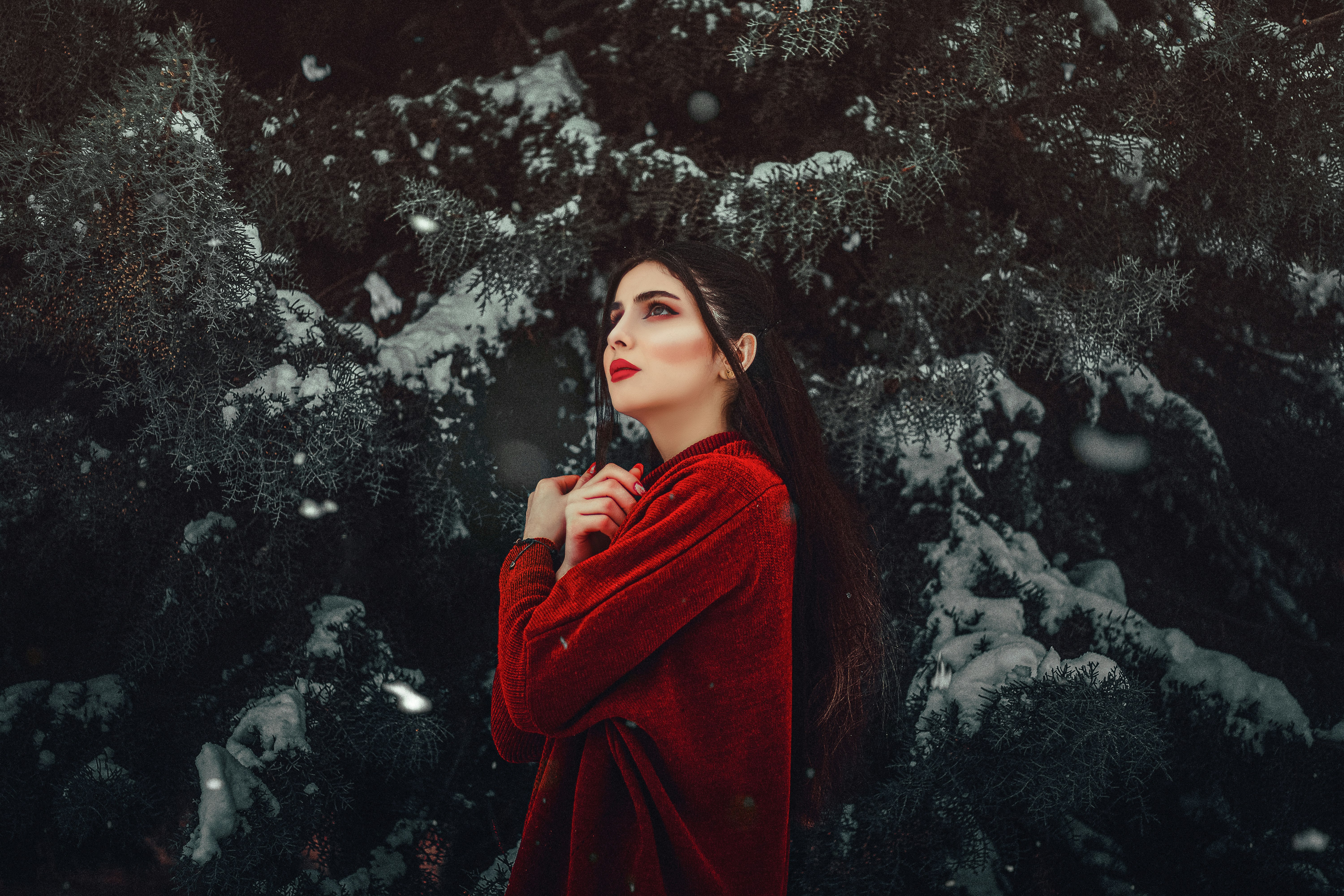 woman in red coat standing near white flowers